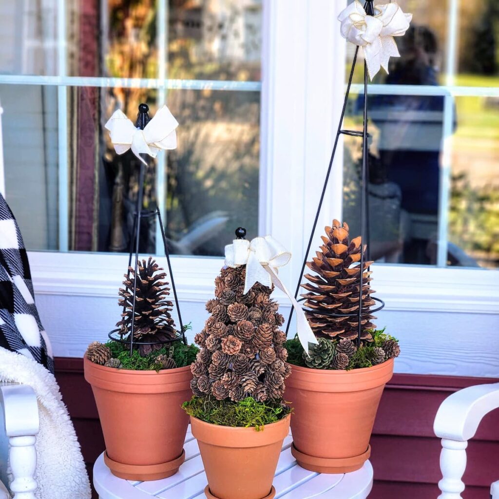 three pinecone topiary trees on front porch table