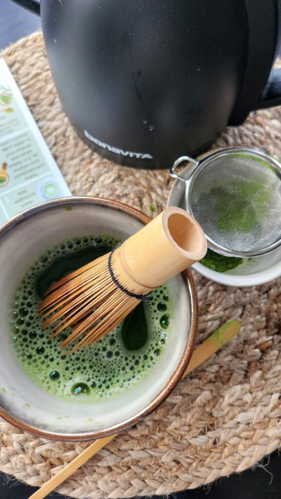 green matcha being whisked in bowl