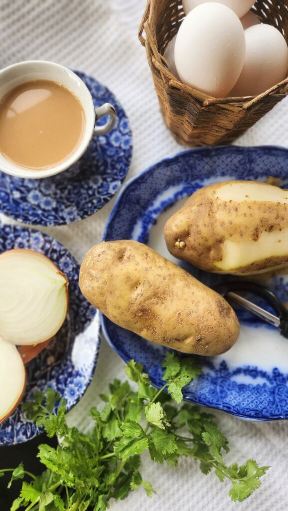 vintage blue dish with potatoes and onion ready to be chopped