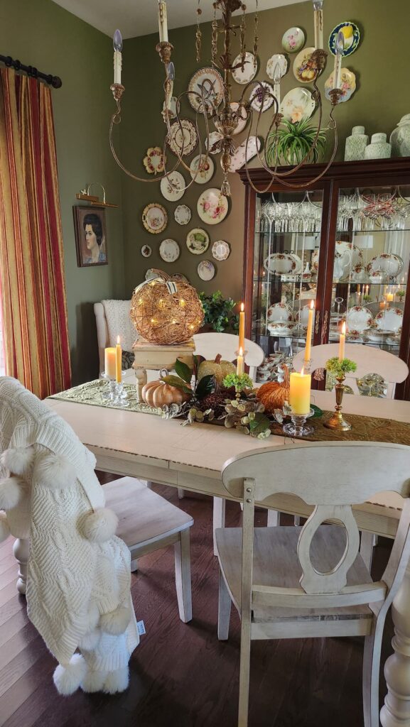 dining room table with center piece arrangement of pumpkins and candles