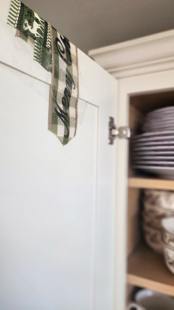 ribbon attached to back of cabinet door with packing tape