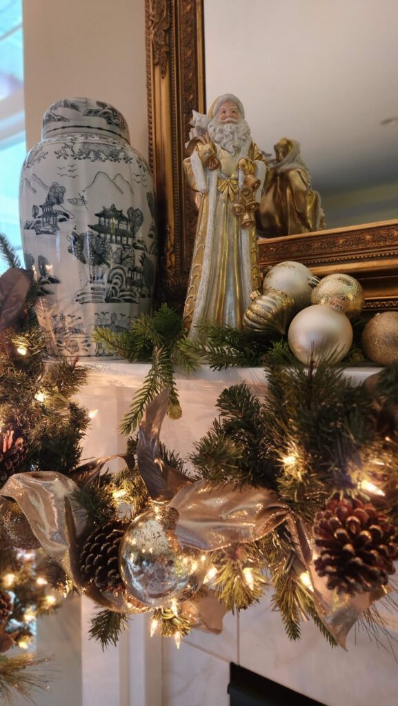 christmas mantel with santa on mantel shelf decorated in gold and ivory