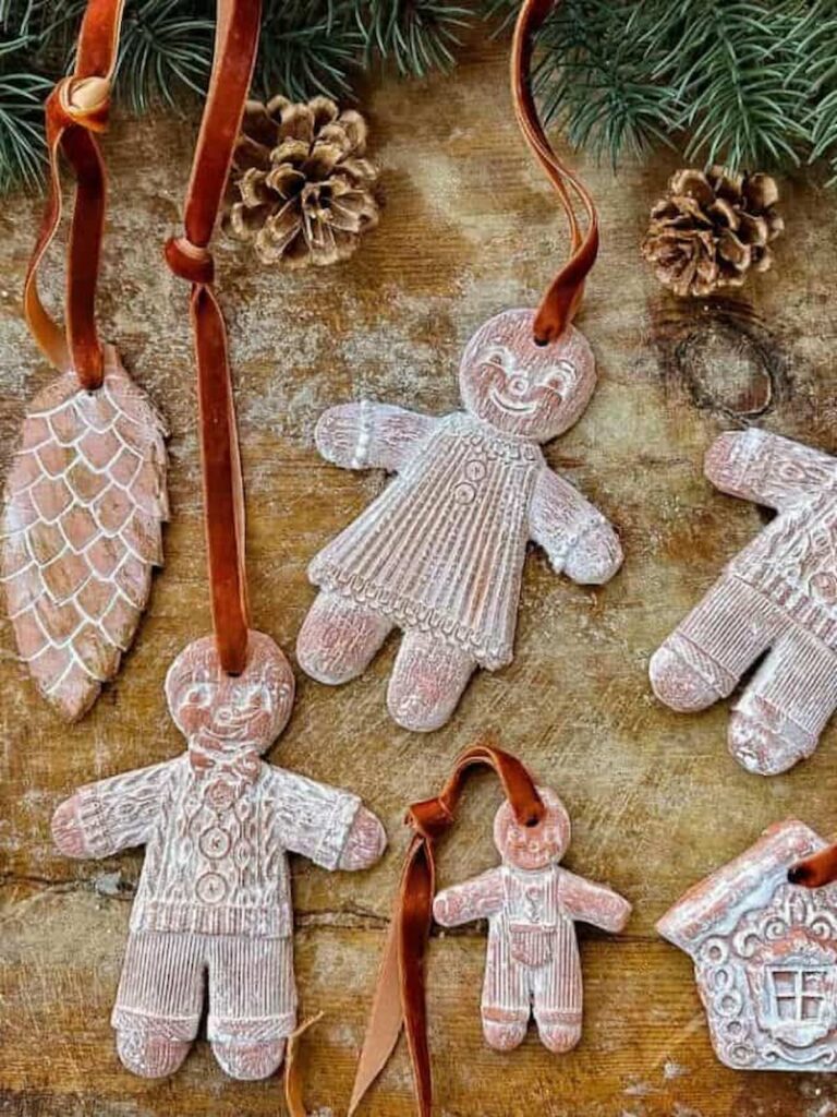 Gingerbread Air Dried Clay ornaments are lying on a cutting board.