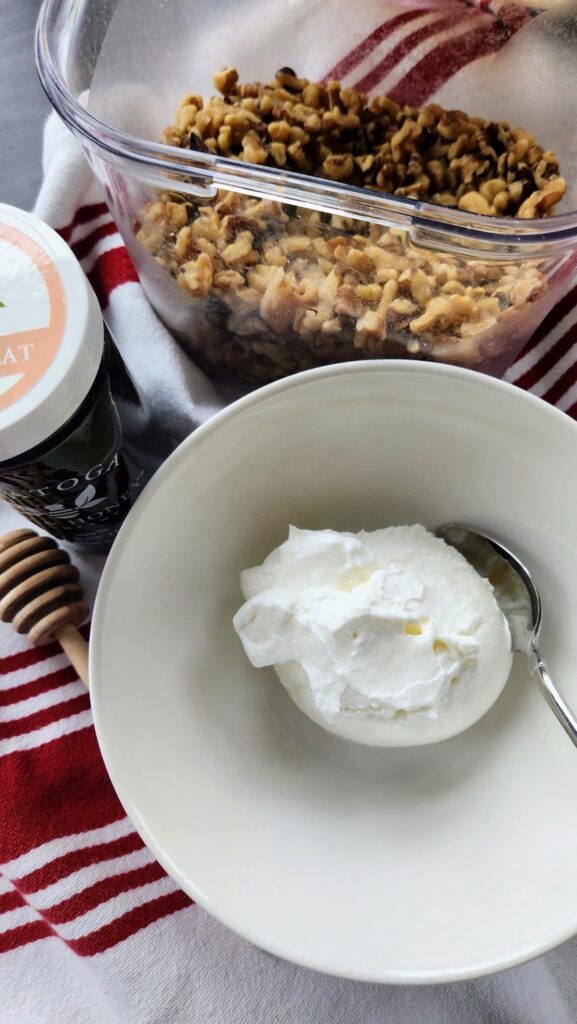 greek yogurt next to jar of buckwheat honey and honey dipper