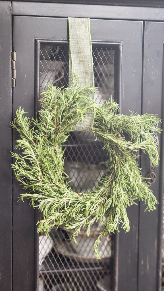 rosemary wreath hanging on mesh cabinet door