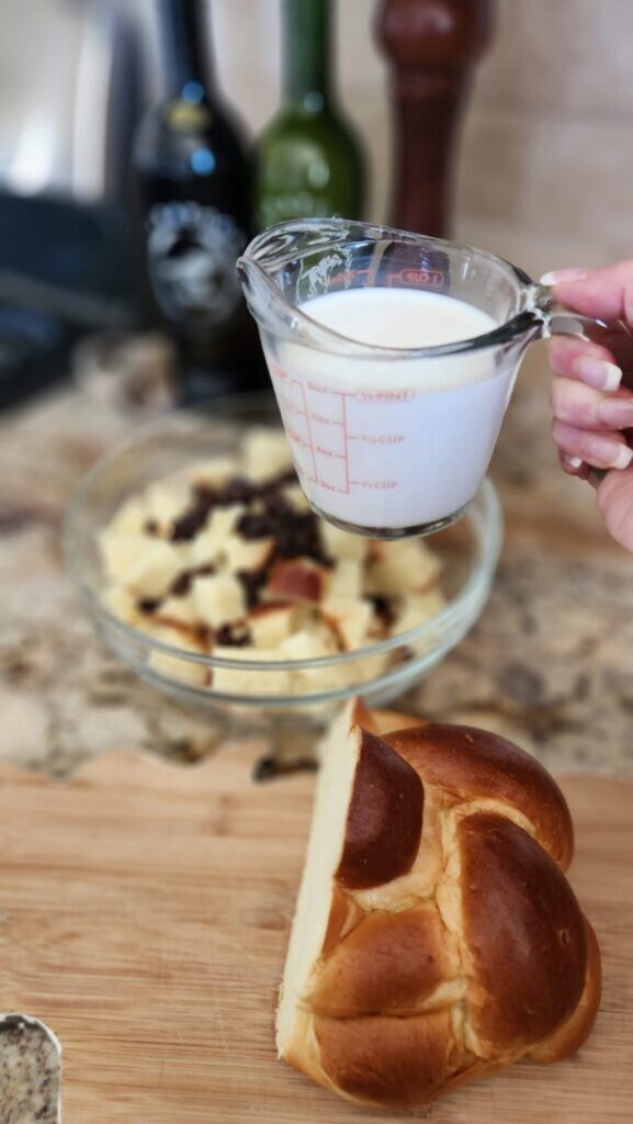 cup of milk ready to go into bread pudding mix