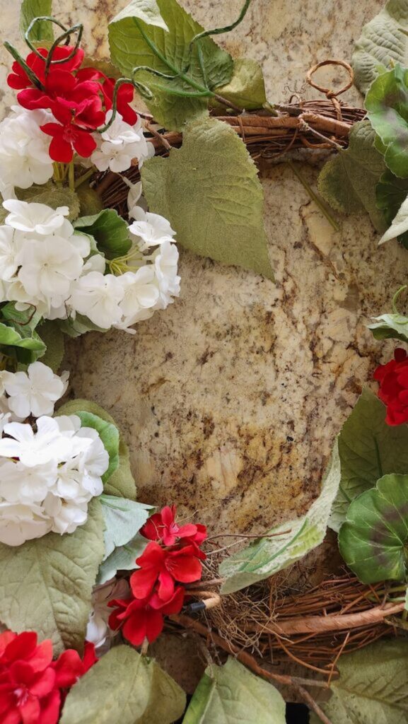 grapevine wreath with old red and white flowers