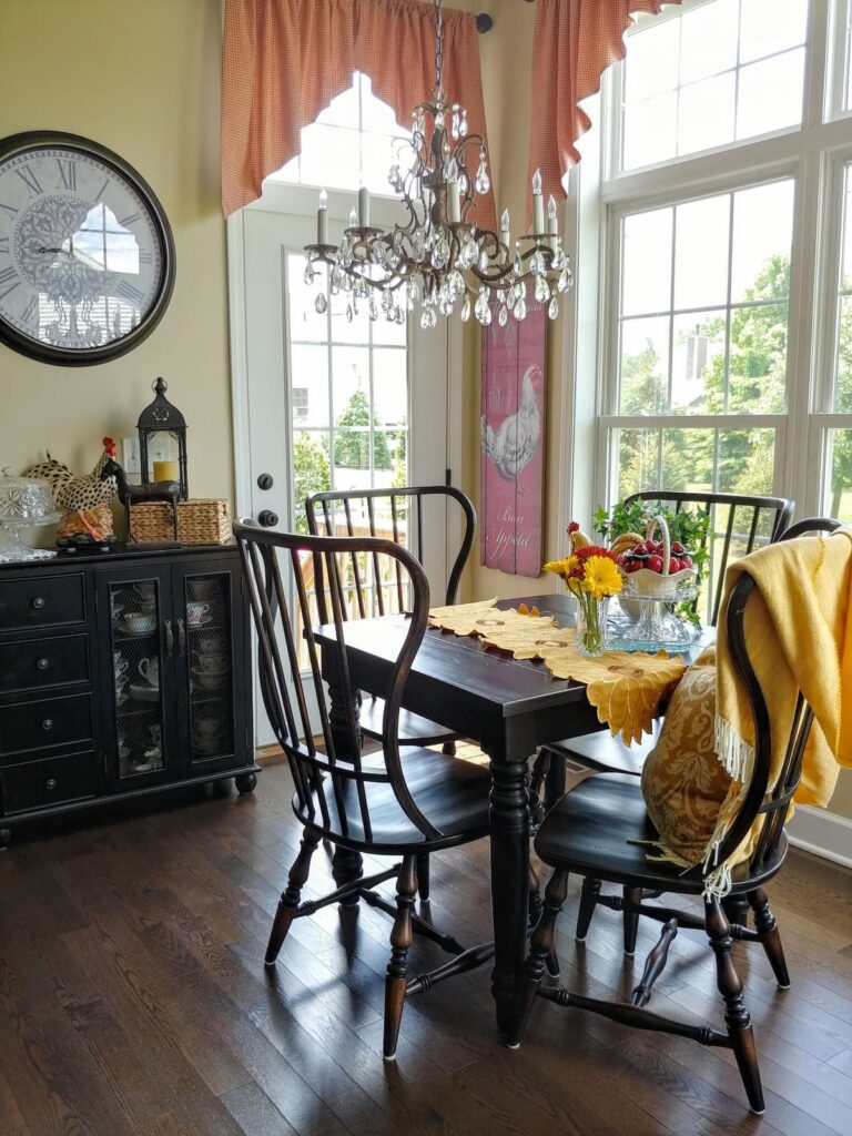 Kitchen table and chairs with large clock on wall