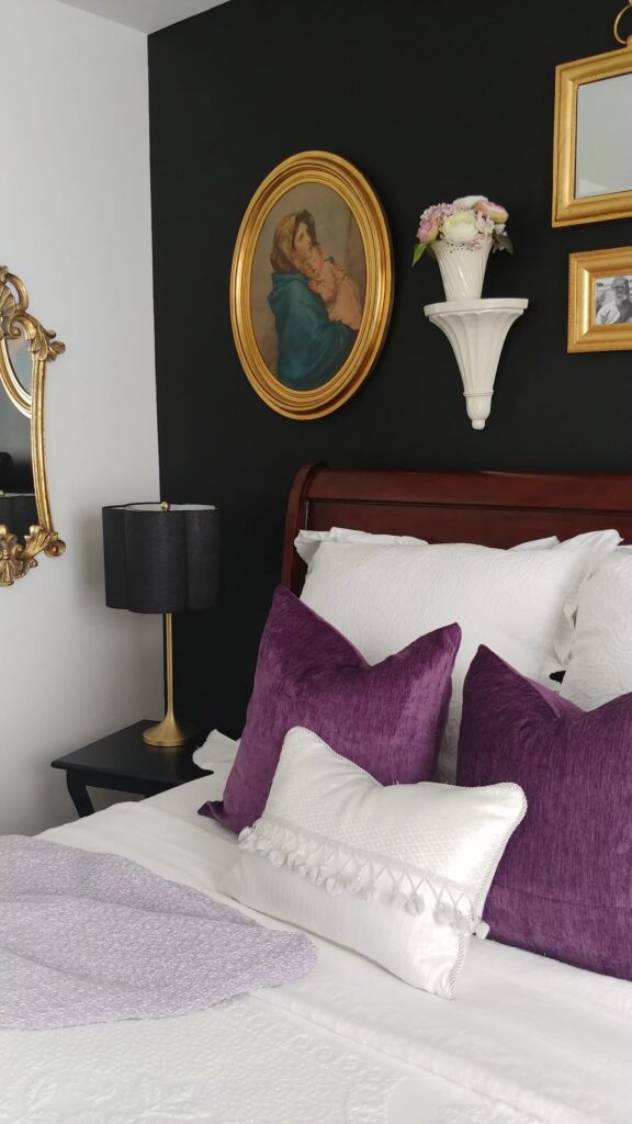black accent wall with gold frames on wall