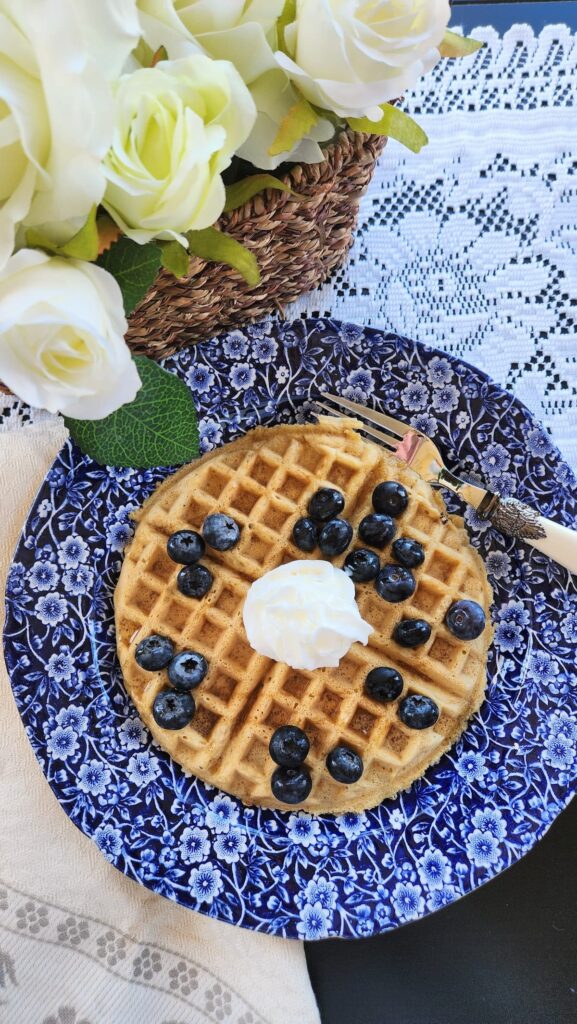 overhead view of easy waffle recipe without milk and with blueberries and whipped cream on top