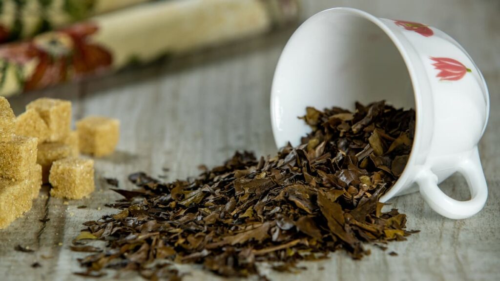 tea cup with tea leaves spilled out of it