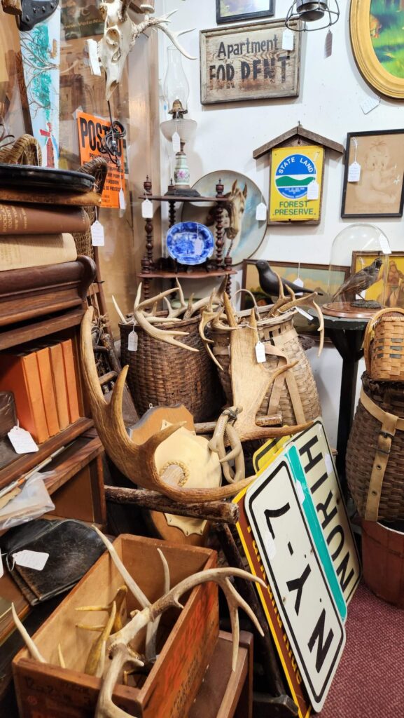 deer antlers, old signs and wicker baskets in a corner of a vintage shop