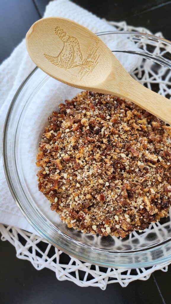 large glass bowl with ground flax seeds, dates and brazil nuts