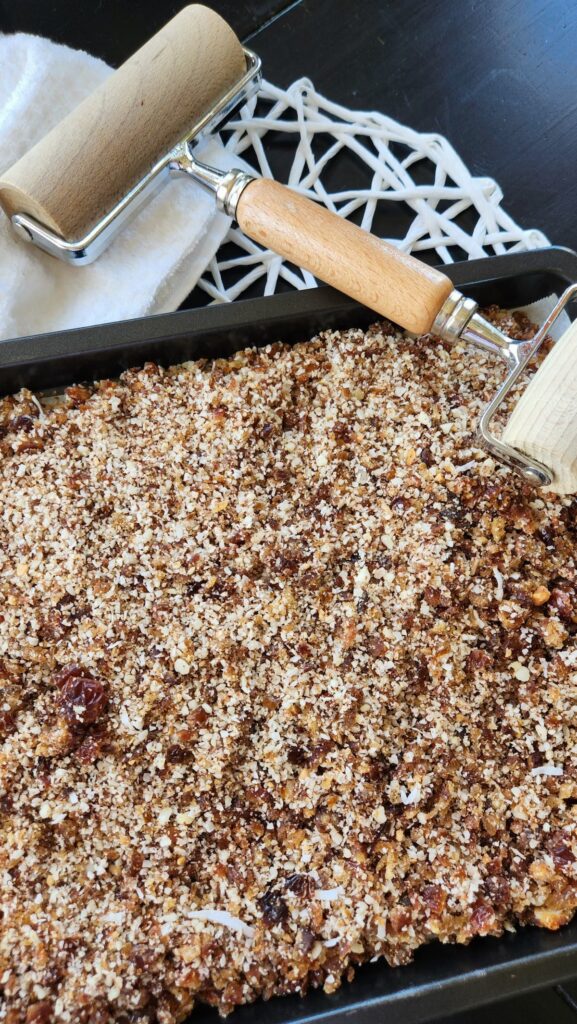 flax seed bar mixture being rolled in a baking sheet