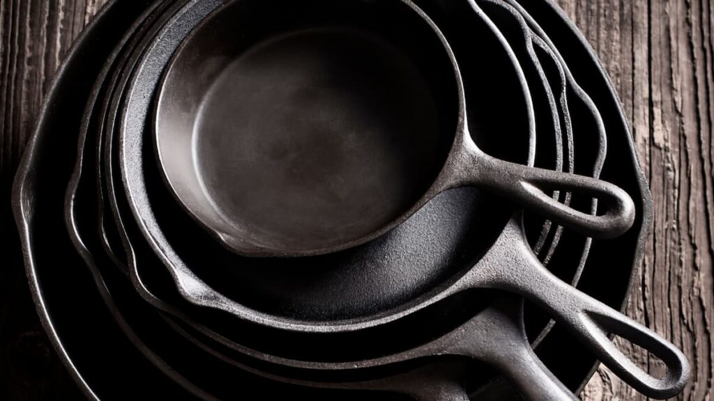 cast iron skillets on table each one on top of the other