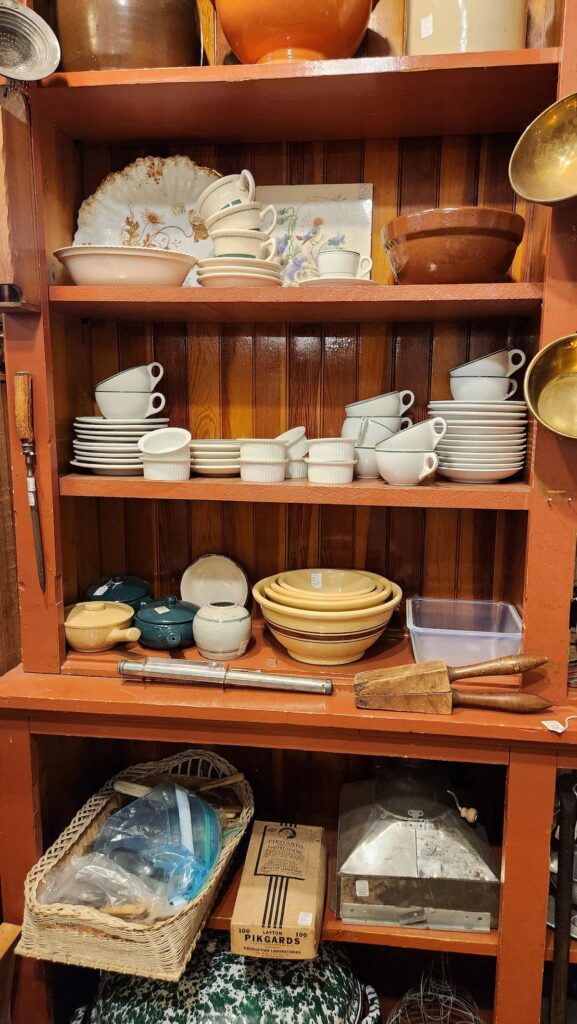 large wood cabinet with vintage dishes and bowl on the shelves