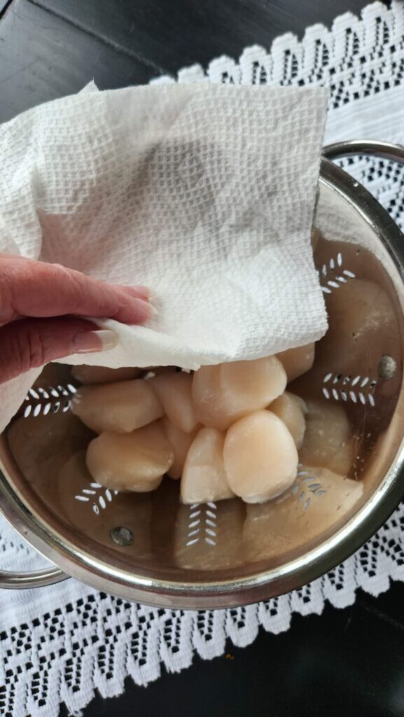 scallops being dried with paper towel