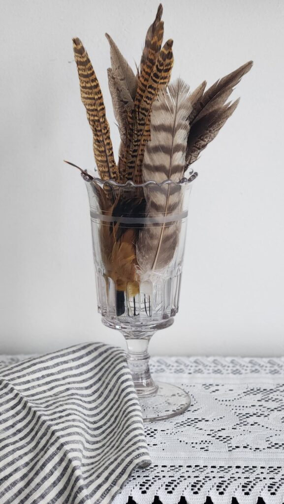 crystal celery jar with feathers styled in it