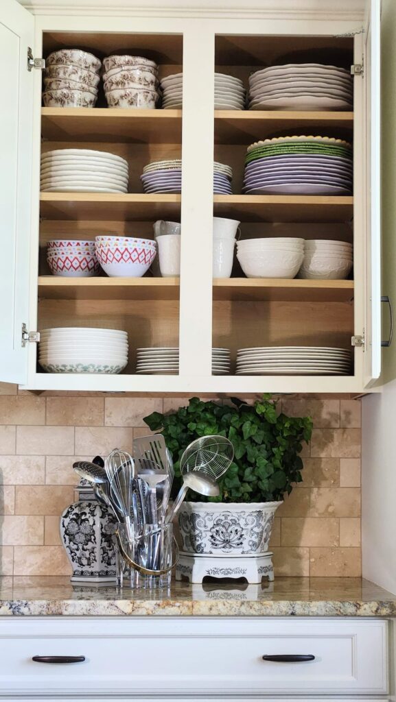 kitchen cabinet that has been organized with dishes in sets