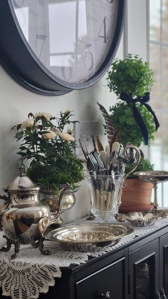 silver coffee pot and other silver items on sideboard ready to use