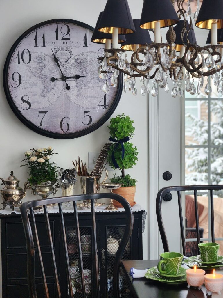 silver pieces on sideboard in breakfast room with cabbagewre dishes on table