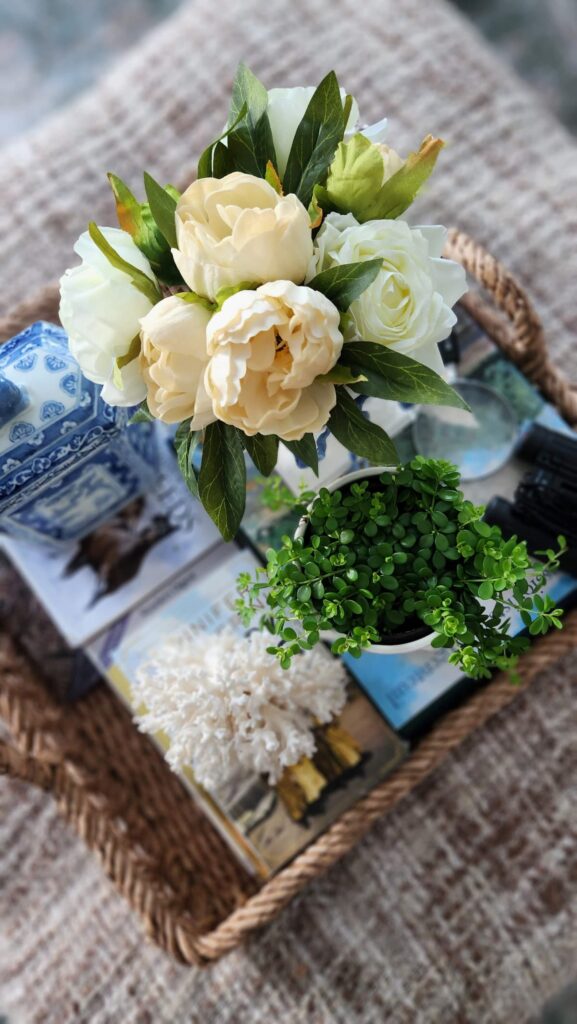 overhead view of living room ottoman eith flowers and a fresh plant from trader joes
