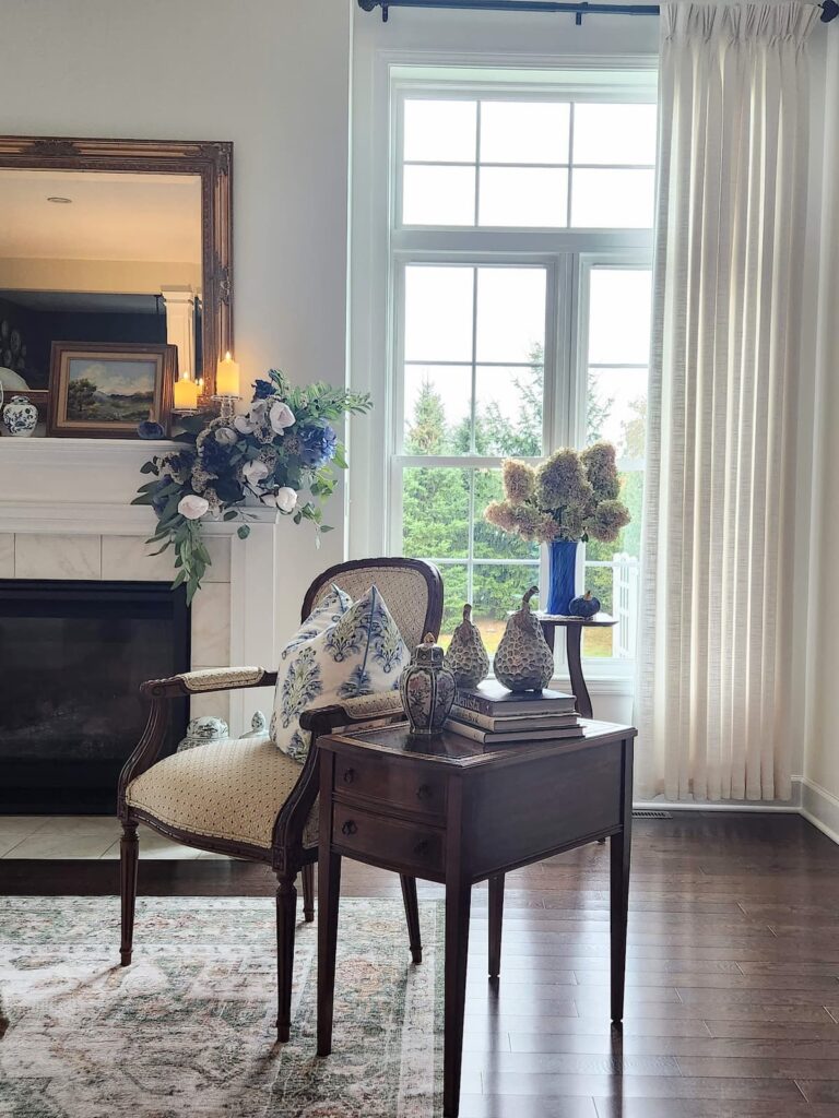 French farmhouse living room with gold mirror mantel and blue and white decor