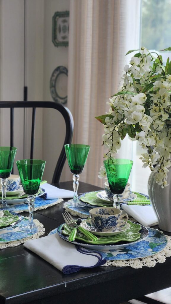 green goblets on table with mismatched dishes