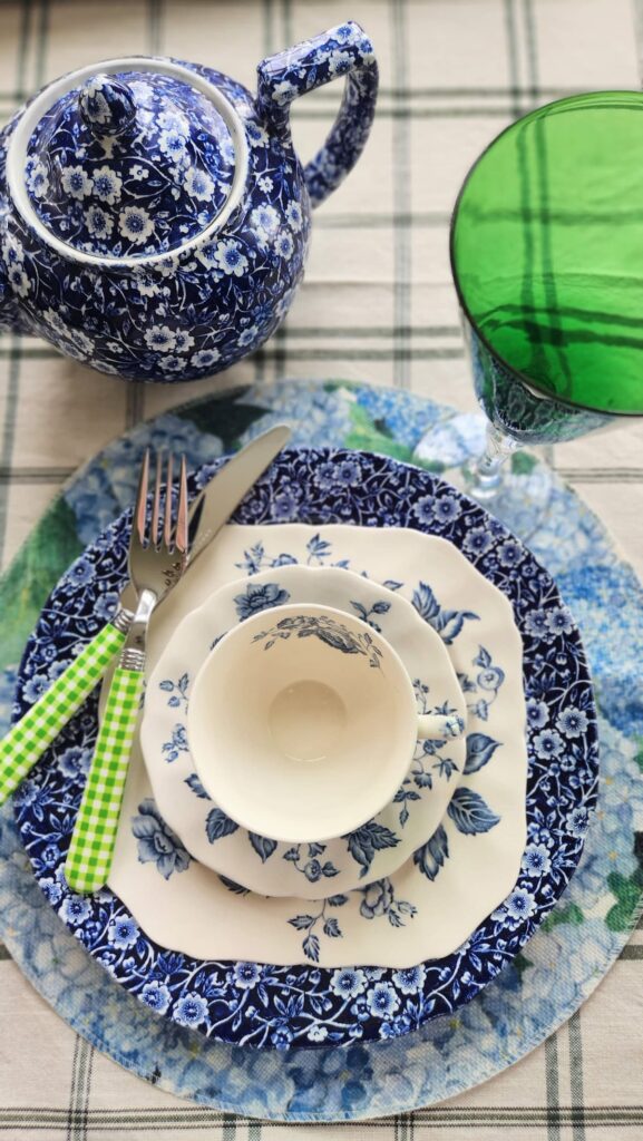 mismatched dishes with blue chintz, green goblet