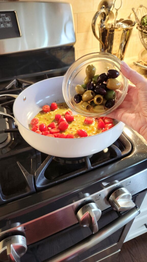 adding kalamata and green olives to mediterranean seafood skillet sauce