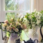 How to arrange spring flowers in a vintage vase breakfast room two arrangements pink roses lavender pitcher white wisteria white pitcher crystal chandelier French country decor