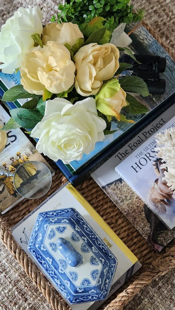 How to style a decorative tray close up detail cream roses blue and white ginger jar coffee table books wicker tray living room French country decor