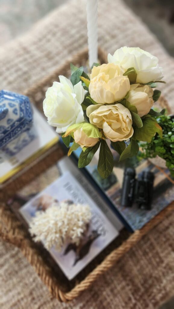 Styled decorative wicker tray ottoman with fireplace background blue and white French country living room decor
