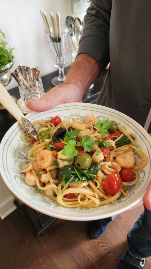 mediterranean seafood blend skillet served over linguine in green vintage bowl