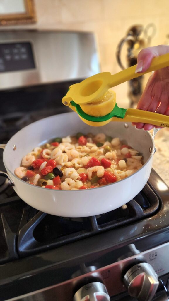 squeezing fresh lemon juice over easy trader joes seafood blend skillet