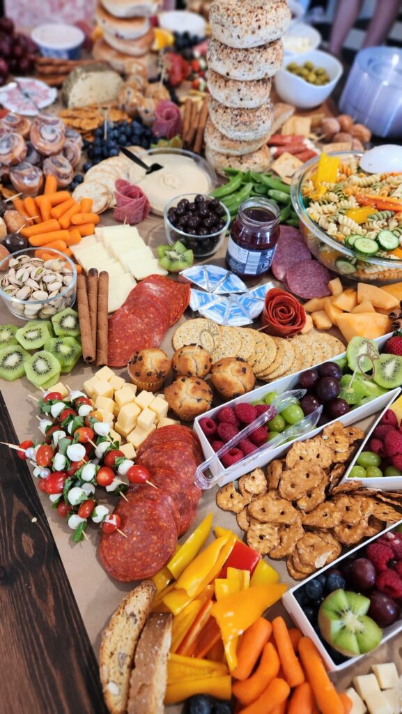 Large charcuterie grazing board with cured meats cheese fresh fruit crackers and vegetables for a crowd