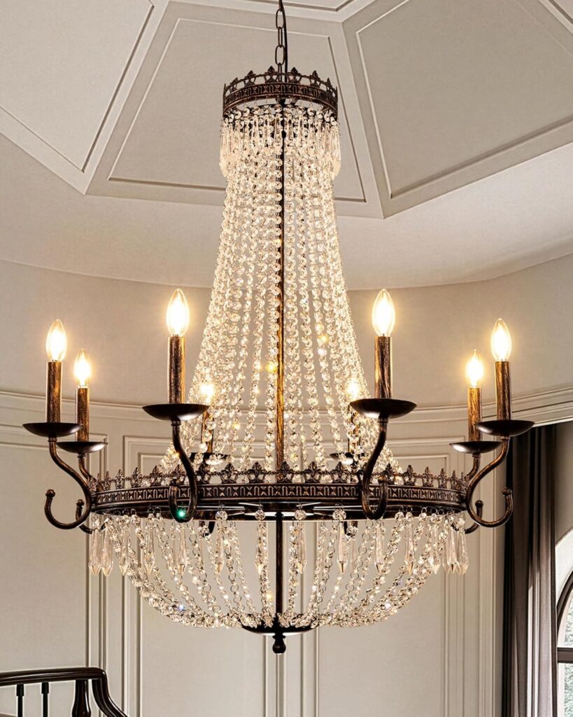 Large crystal and bronze empire chandelier with candle arms lit up in a elegant room