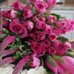Pink spray roses tulips and white hydrangea from Trader Joes on kitchen counter with white teapot and dishes in background