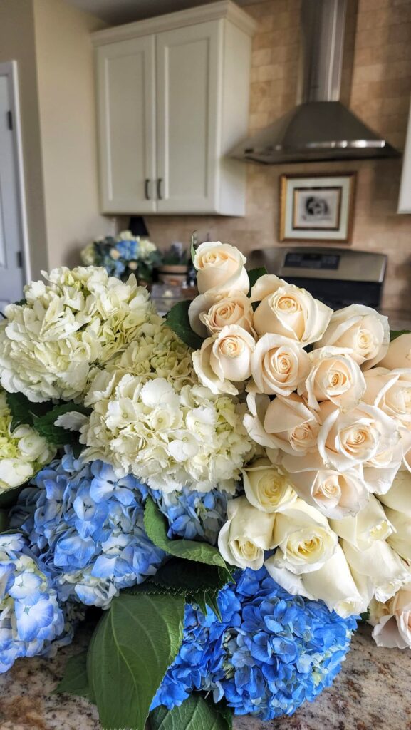 Blue and white hydrangea bouquets with cream roses from Trader Joes on kitchen counter